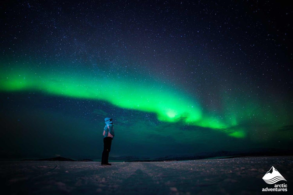 woman watching Aurora Borealis in winter