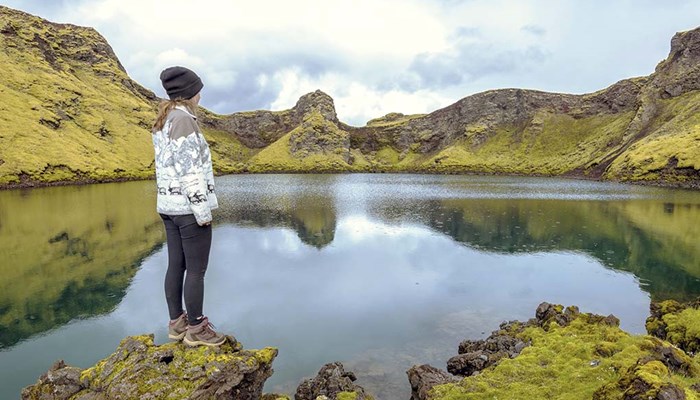 Woman standing on a rock looking out across a lake