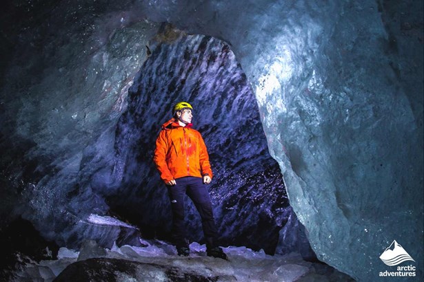 man inside ice cave of Falljokull glacier