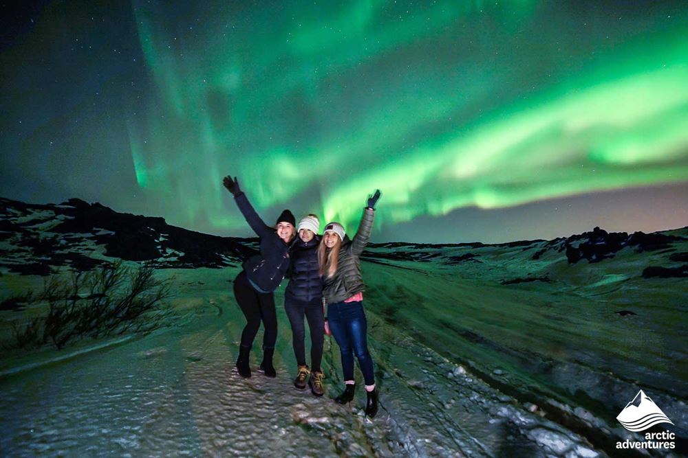 Happy Friends Taking Photo With Northern Lights