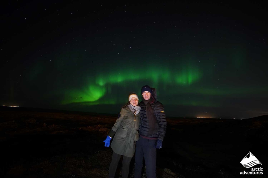 couple smiling under Northern Lights