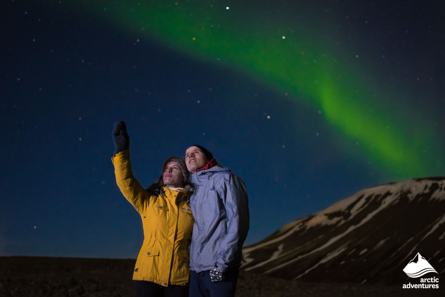 couple watching Aurora Borealis in Iceland