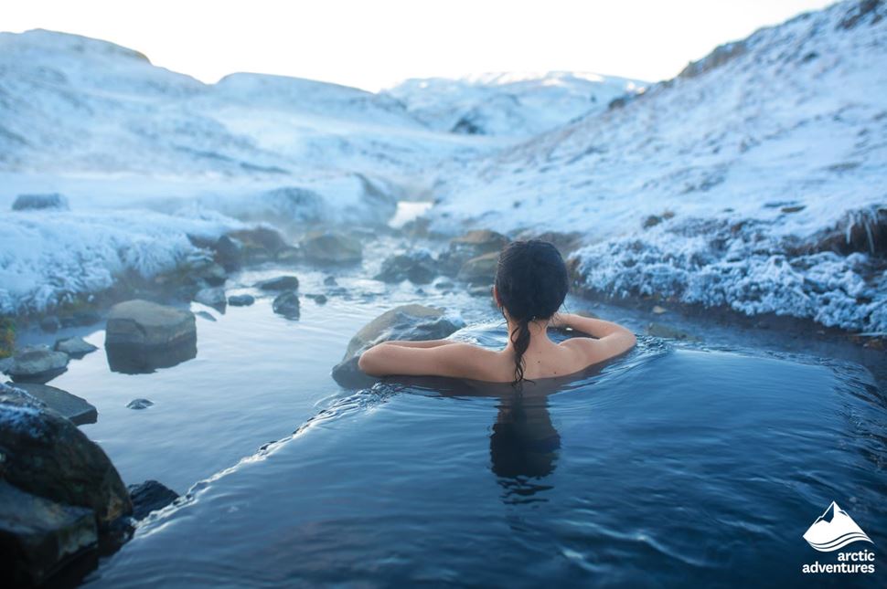 woman bathe in Icelandic hot springs on winter