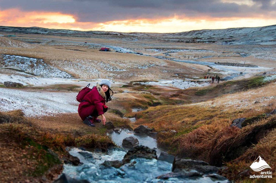 woman exploring geothermal river in Iceland