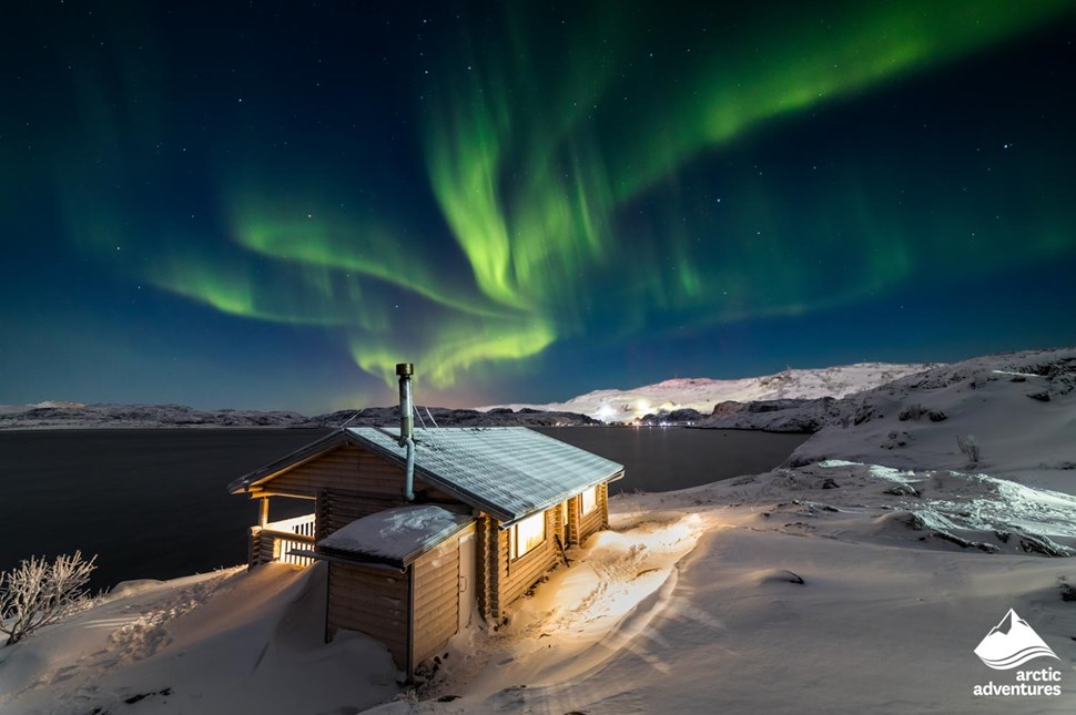 Aurora Borealis over wooden hut in Iceland