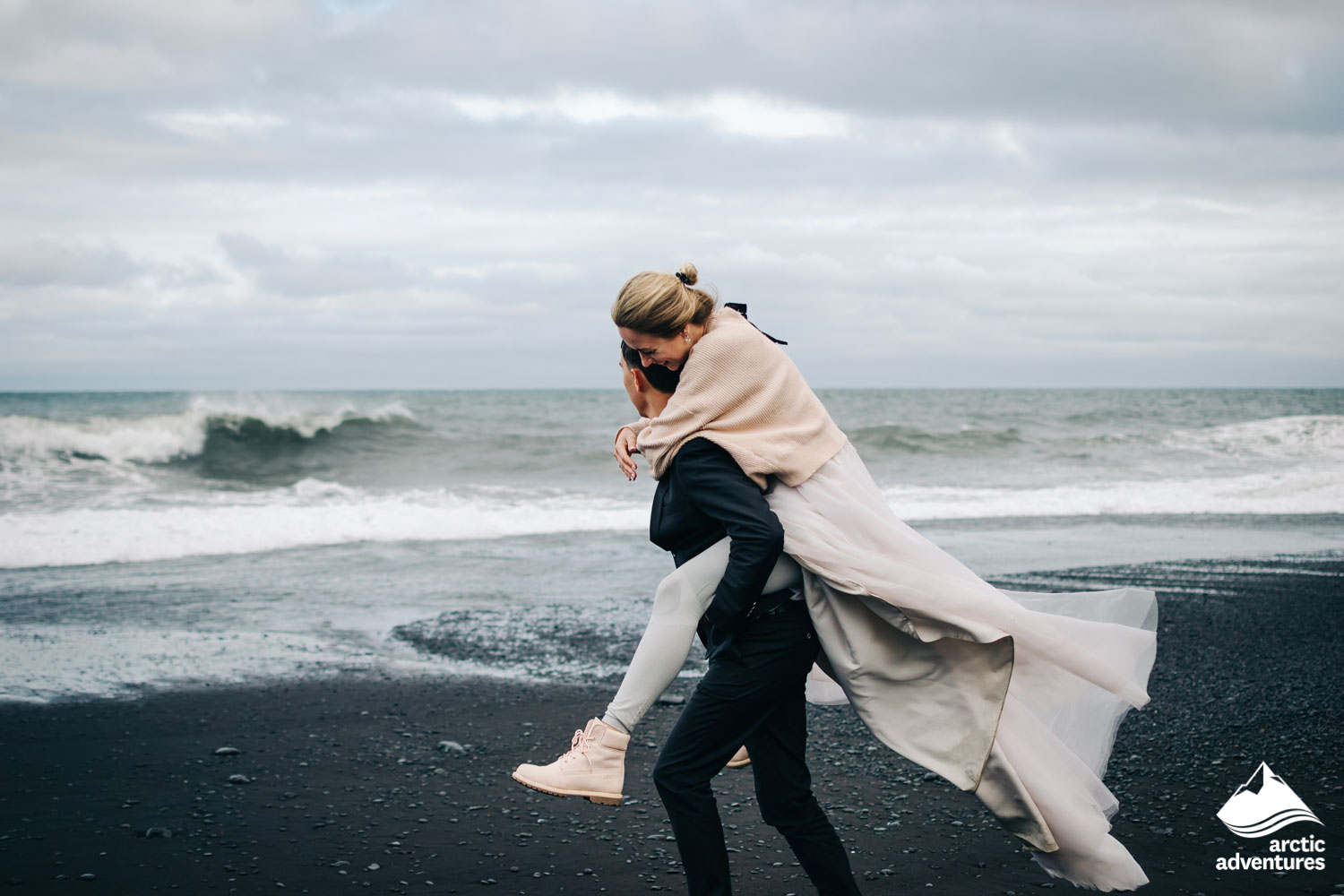 couple on black sand beach in Iceland