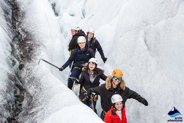 Happy group of people walking in ice crevasse