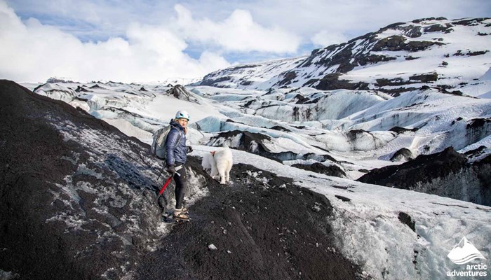 Woman with dog walking on a glacier