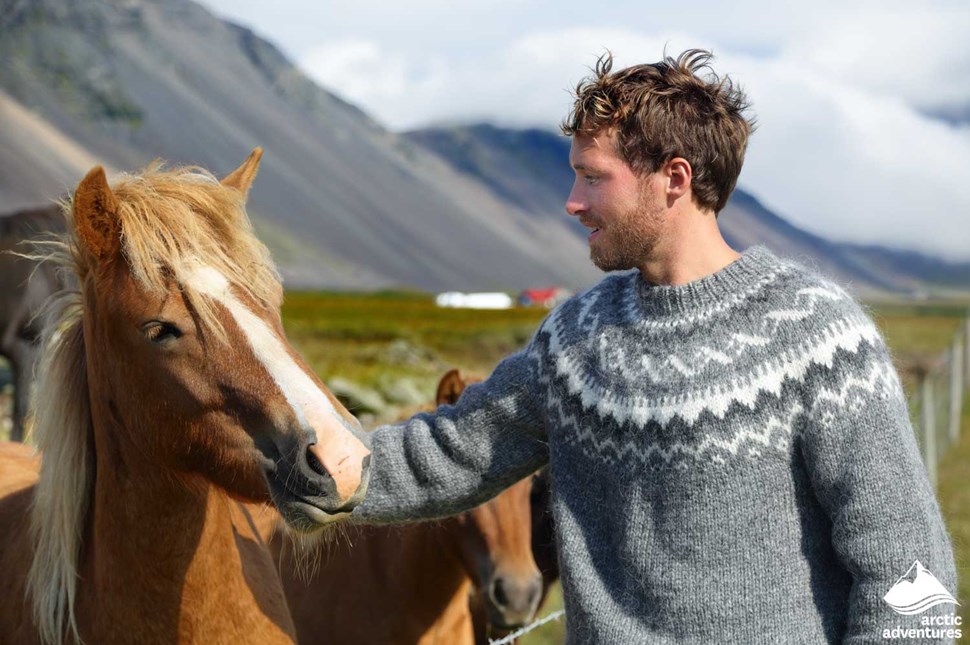 Man Petting an Icelandic Horse in Iceland
