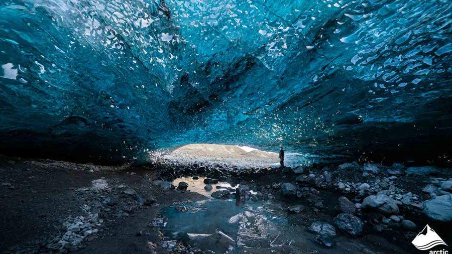 Man Standing Inside of Ice Cave