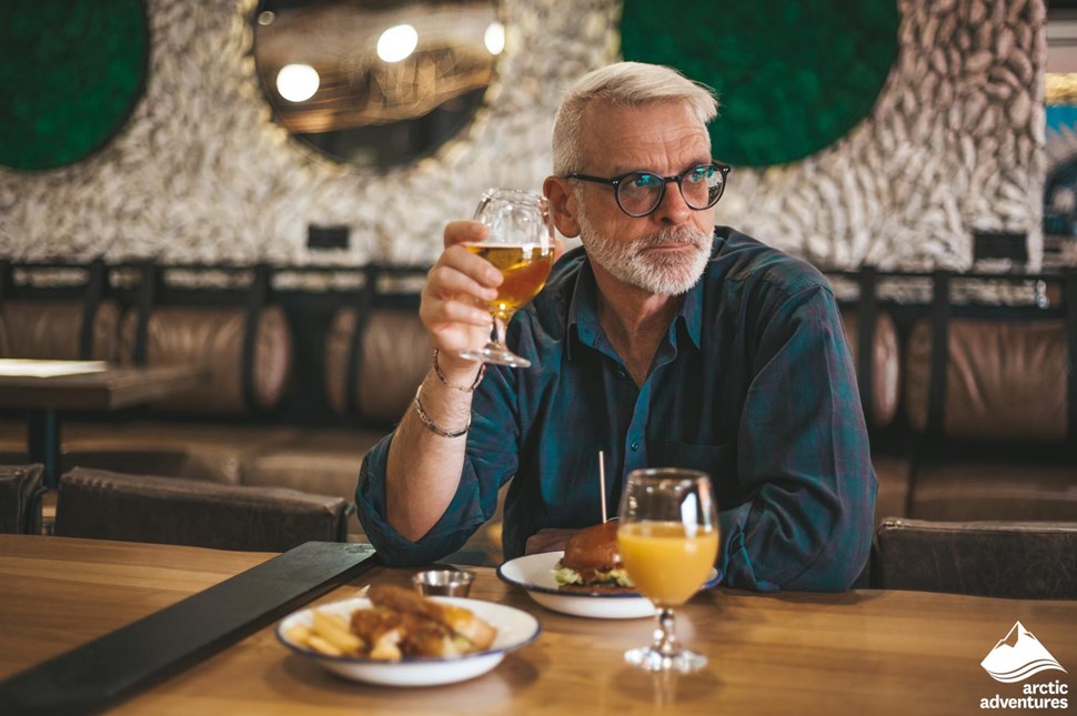 Man Drinking Beer and Eating Lunch at Restaurant