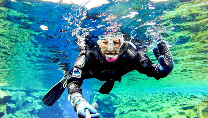 Man holding a thumbs up while snorkeling at Silfra Fissure 