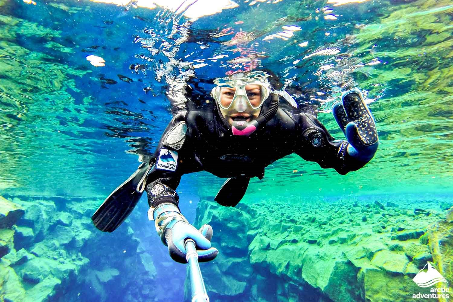 Man holding a thumbs up while snorkeling at Silfra Fissure 