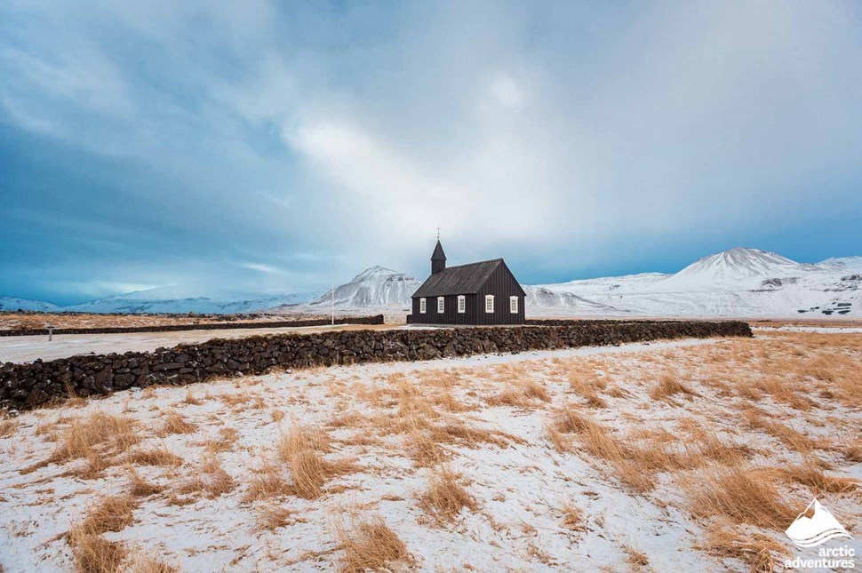 Budir Black Church in a Field by Mountains