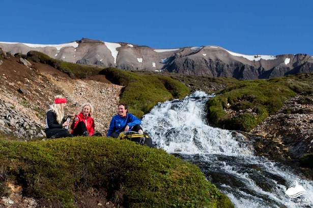 People Resting by Waterfall in Iceland