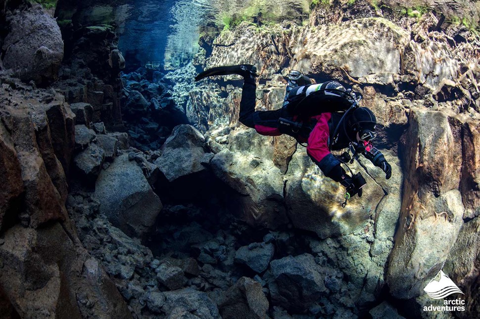Man Diving by Tectonic Plates in Iceland