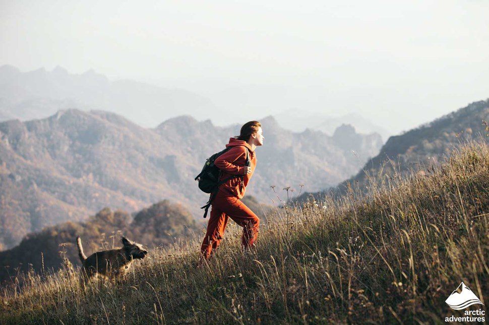 Woman Hiking with Dog in Mountains