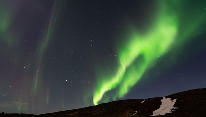 Bright Northern Lights over Hill in Iceland