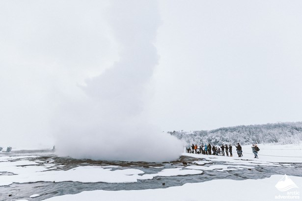 People Enjoying Geyser Eruption in Winter