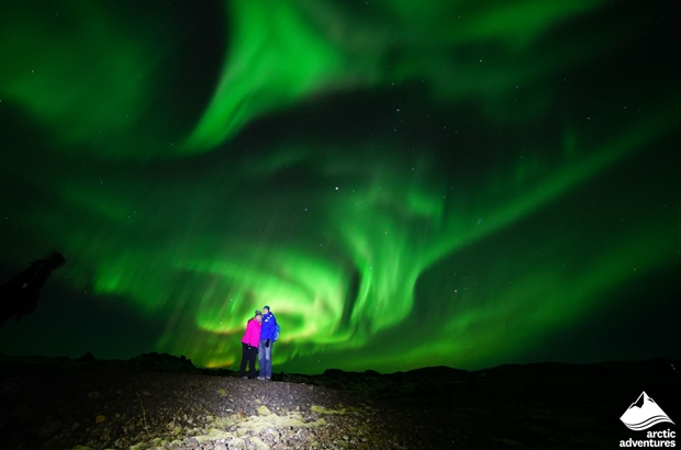 Happy Couple Watching Northern Lights in Iceland