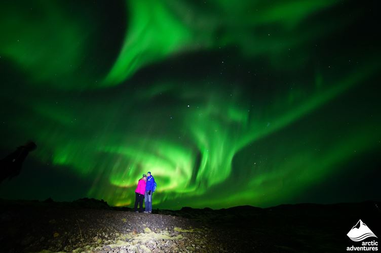 Happy Couple Watching Northern Lights Happy Couple Watching Northern Lights in Iceland
