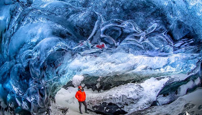 Man with Red Jacket in Ice Cave Iceland