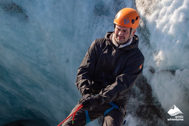 Man Climbing into Glacier Crevasse in Iceland