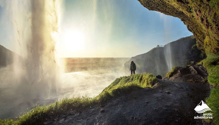 Man Standing by Waterfall in Iceland
