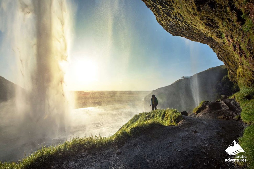 Man Standing by Waterfall in Iceland