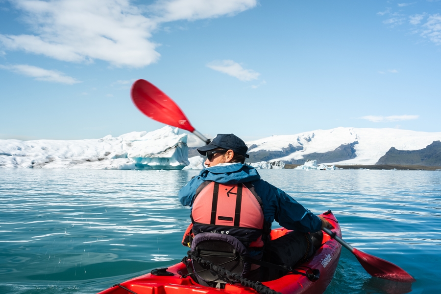 Man Kayaks in Glacial Lagoon
