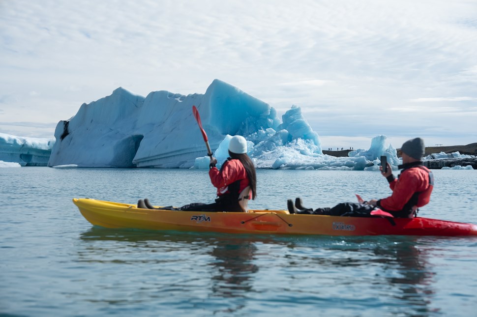 Couple in Kayak near Giant Iceberg