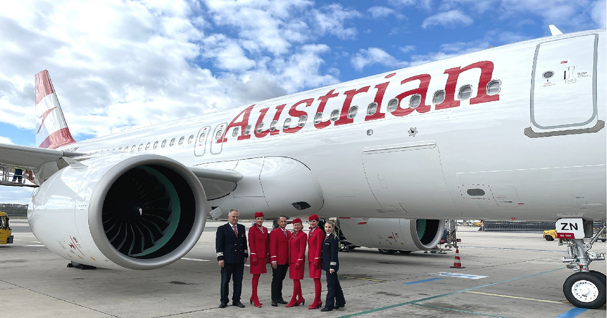 Pilots and crew members posing in front of Austrian Airlines plane