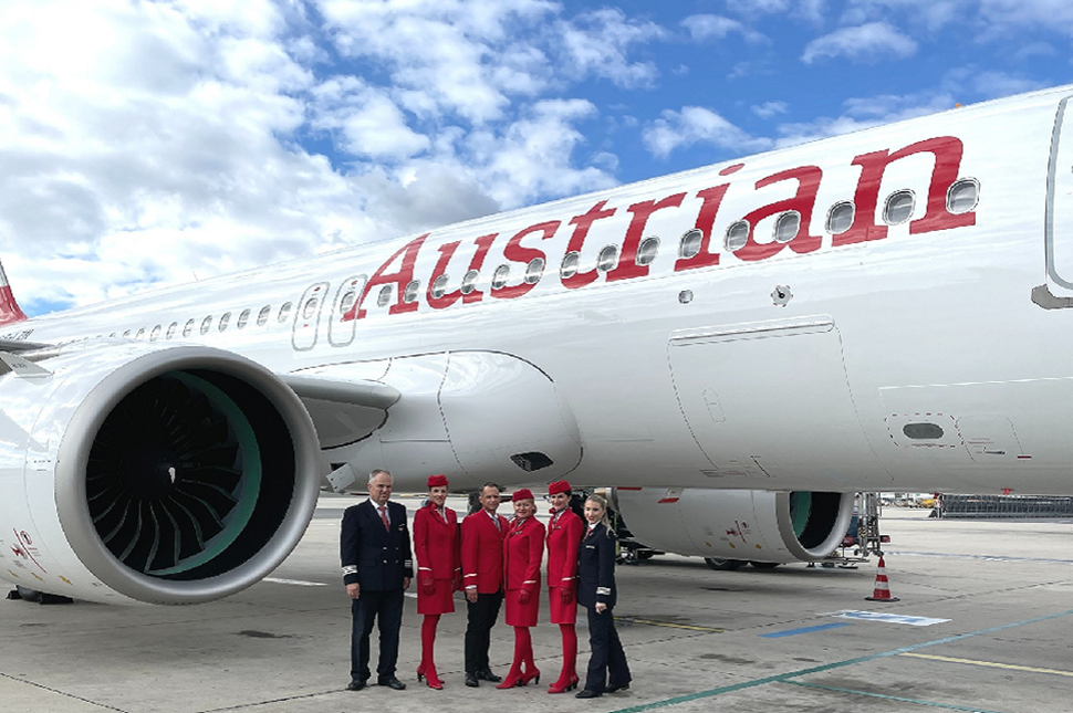 Pilots and crew members posing in front of Austrian Airlines plane