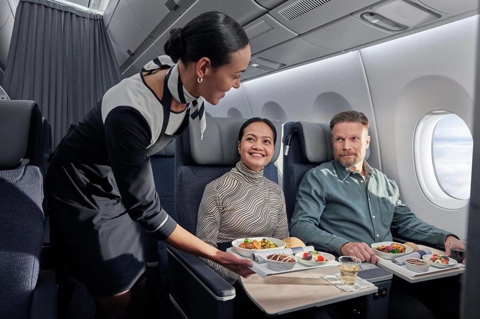 Stewardess serving first-class passengers on a plane