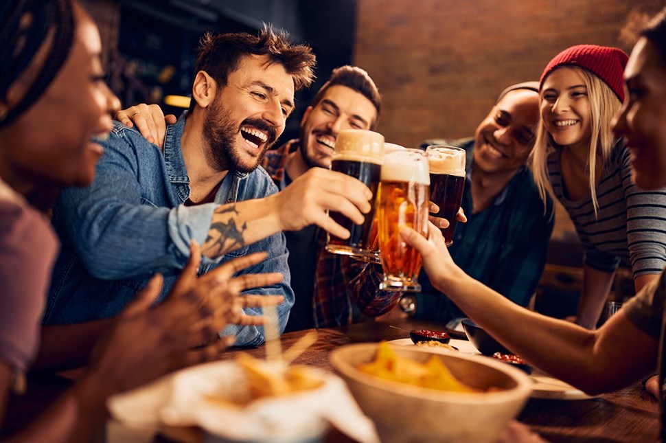 Group of smiling people saying cheers before drinking