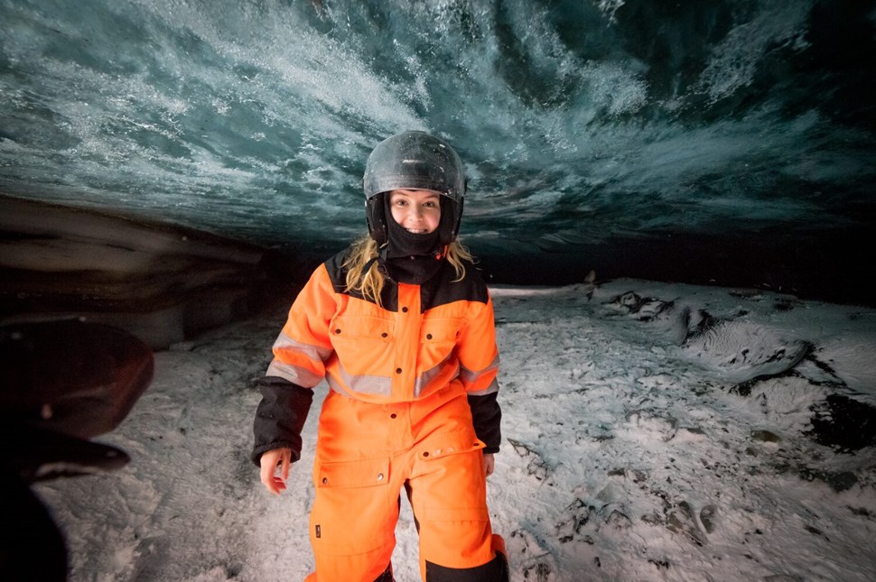 Woman in snowmobiling gear in an ice cave