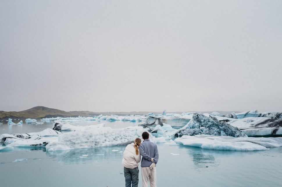 Couple standing on diamond beach shore in Iceland