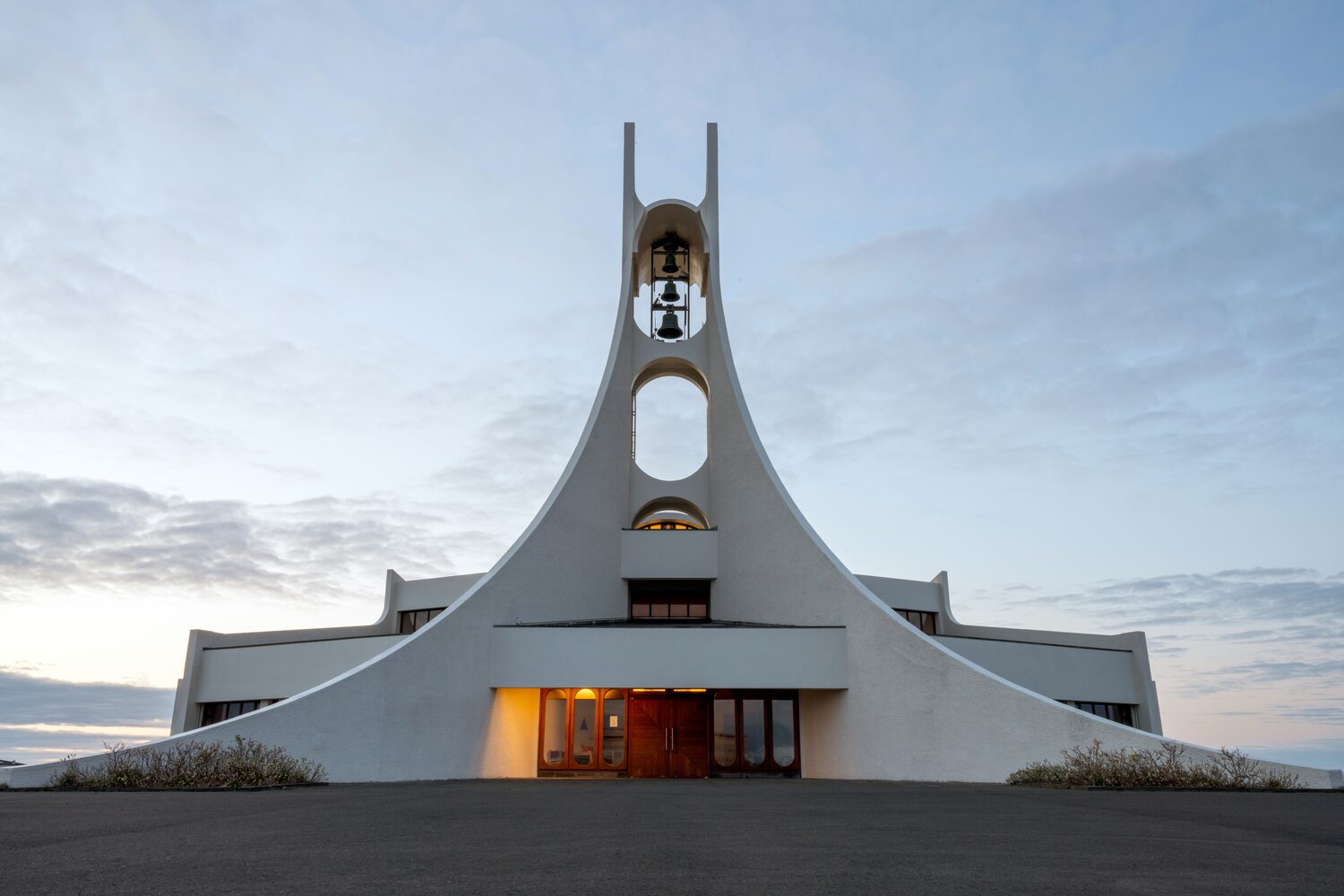 Church with bell tower featuring dual arches rising against muted sky