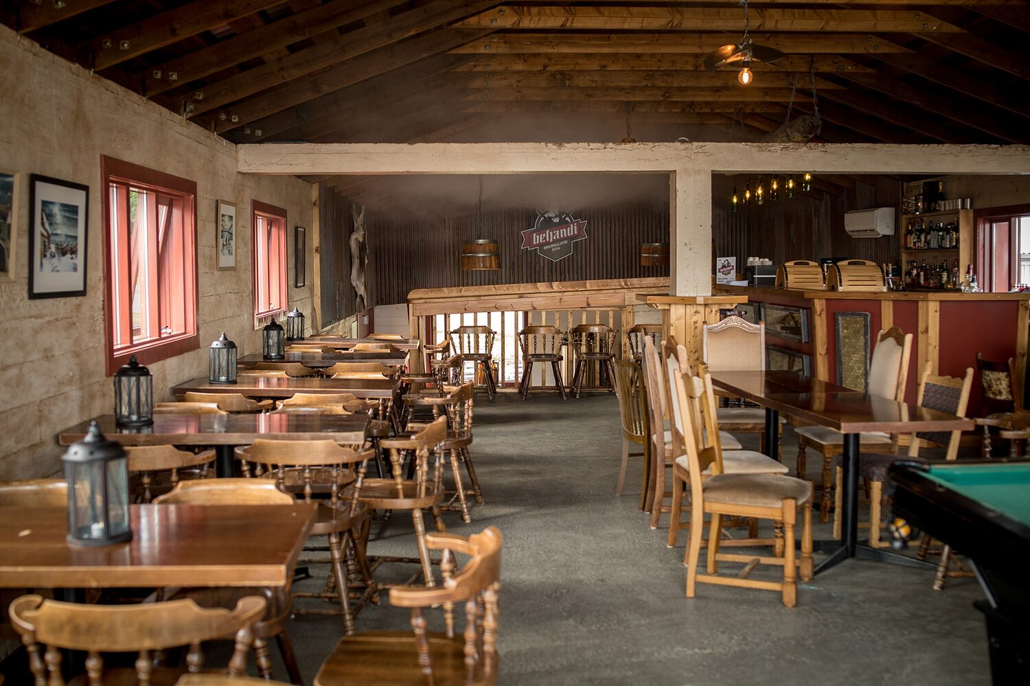 Vintage brewery interior with wooden tables, chairs, and a bar counter
