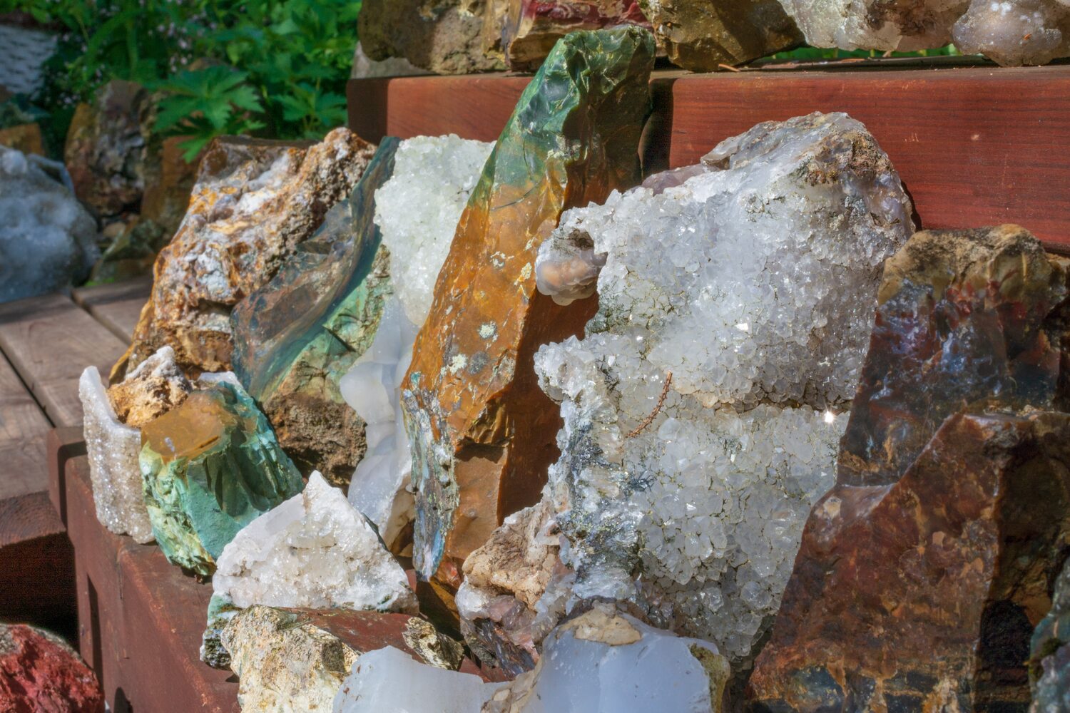Assortment of colorful crystals and minerals displayed on wooden shelf