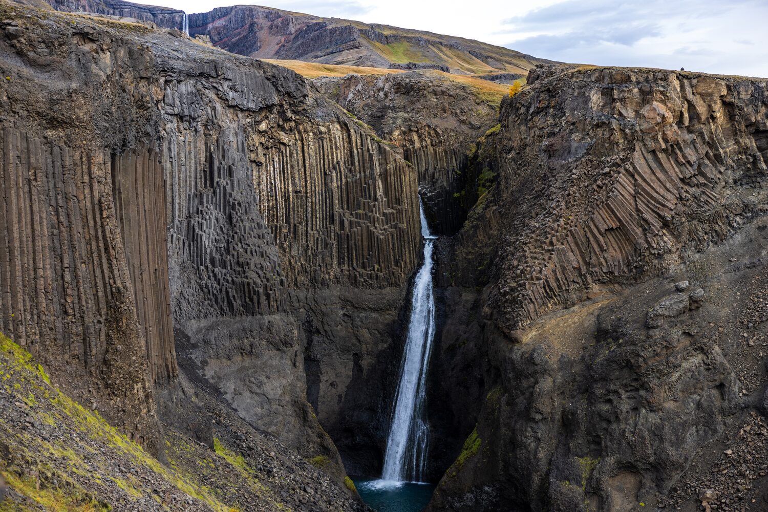 Majestic waterfall plunges amidst striking columnar basalt cliffs