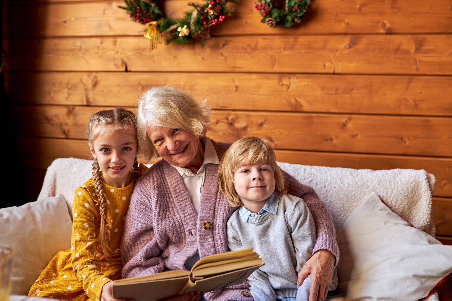 Lovely elderly woman read fairy tales for children on Christmas.