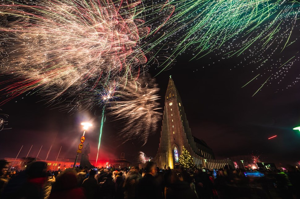 Fireworks illuminate the night sky above Reykjavik's iconic Hallgrímskirkja church during Iceland's festive season.