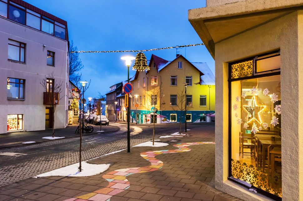 Cozy Icelandic street adorned with Christmas lights and decorations at dusk.