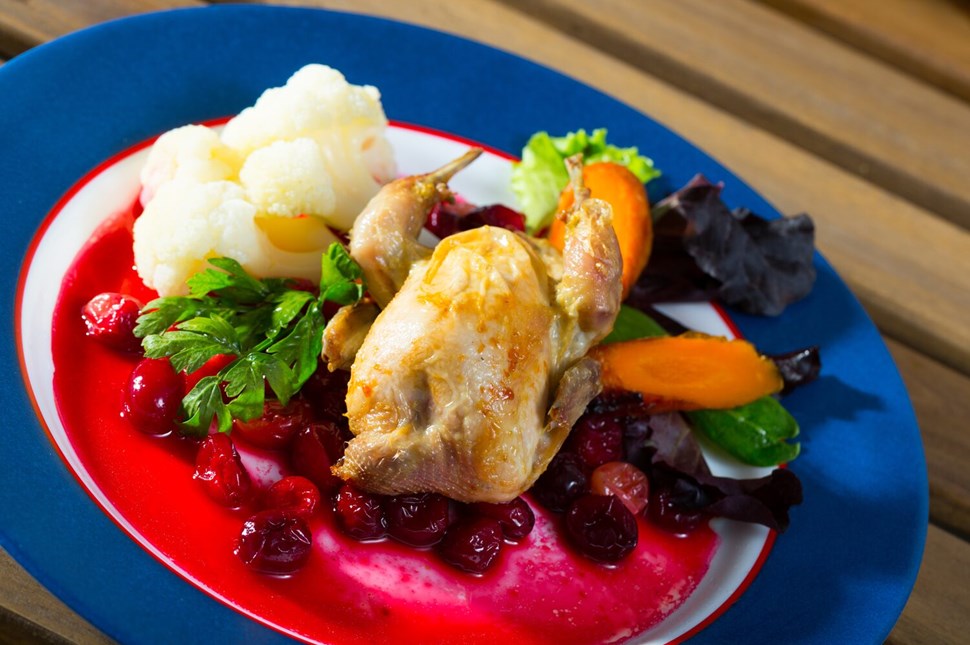 Plate of traditional Icelandic Christmas meal with roasted poultry, vegetables, and lingonberry sauce.