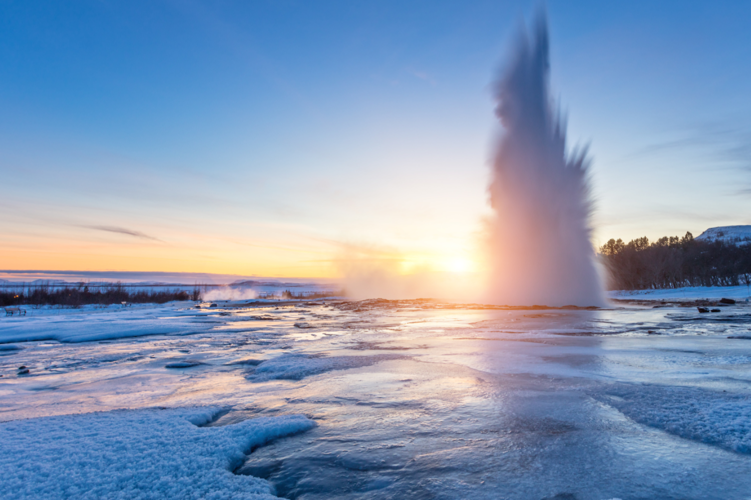The famous Geysir in Iceland on a snowy day at sunset