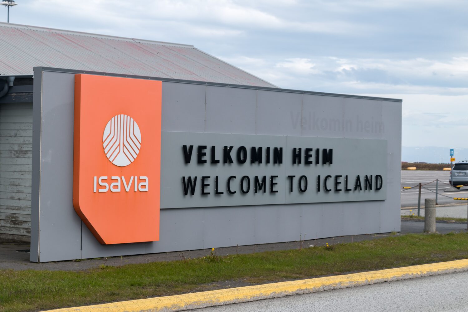Entrance sign at Keflavik Airport displaying Welcome to Iceland in bold letters.
