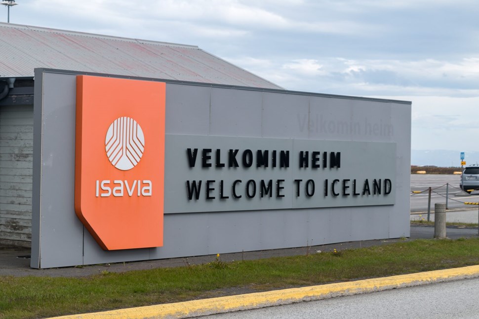 Entrance sign at Keflavik Airport displaying Welcome to Iceland in bold letters.