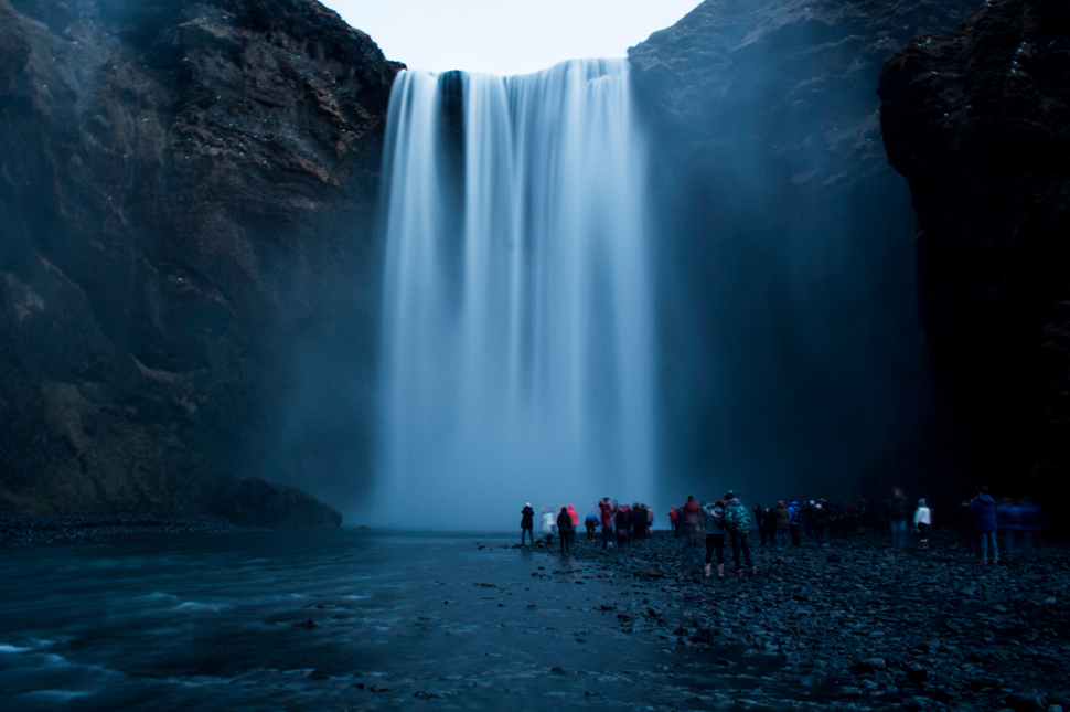 People gathering under Skogafoss waterfall in Iceland