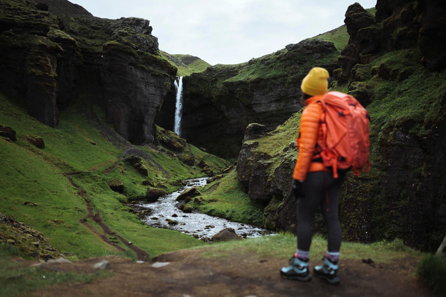 Woman looks at the waterfall in the mountains